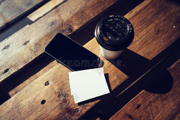 空白白色名片模型。智能手机高纹理木桌带走咖啡杯咖啡。准备工作现代办公室