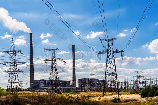 前景中的燃煤发电厂和输电线路。