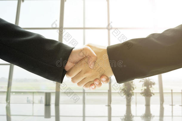 商务人员握手在办公室背景，概念业务