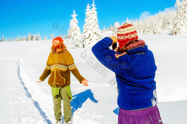 一个男人在美丽的山上雪景中的女孩照片。