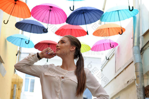 女孩在五颜六色的雨伞<strong>下摆</strong>姿势