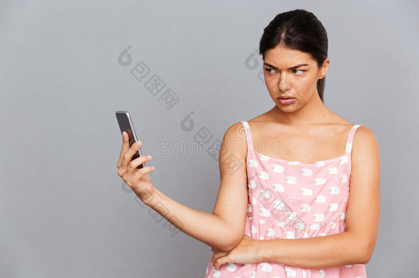 穿着粉红色连衣裙的女人在智能手机上拍自拍照片