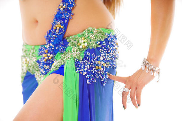 腹部舞者的特写臀部穿着蓝色和绿色的裙子，摆出表演<strong>舞蹈</strong>动作，明亮的<strong>工作室</strong>