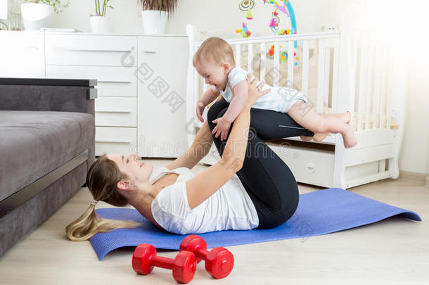 美丽<strong>的母亲</strong>和她<strong>的</strong>孩子在<strong>我的</strong>地板上做瑜伽运动