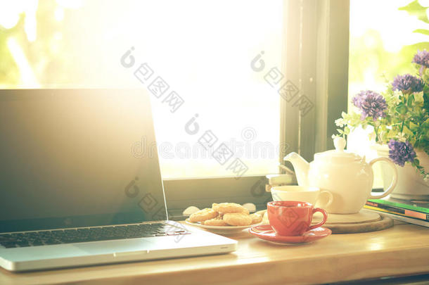咖啡杯，茶壶，饼干和笔记本电脑