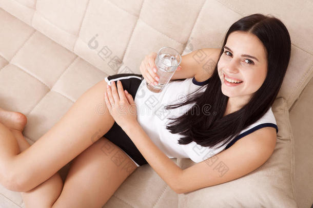 女孩在家喝水。 早餐前早上喝一杯水。 异常的，顶部的视图。