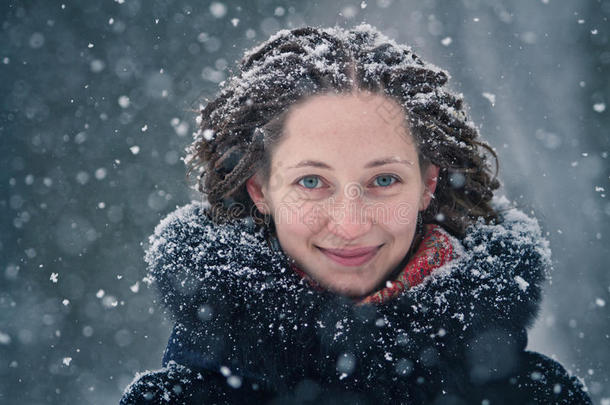 美丽的女孩冬天的肖像与飞舞的雪花