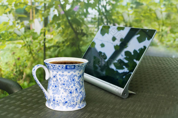 花园里桌子上的一杯茶和数码垫