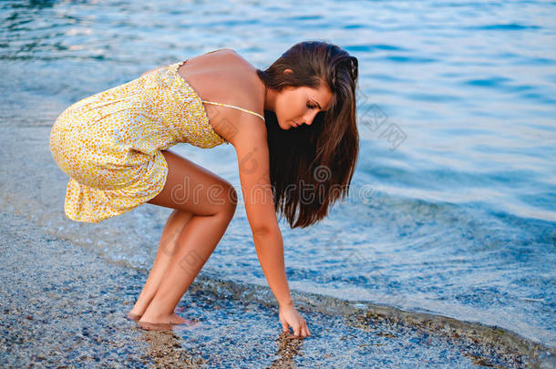 女孩在海滩上捡贝壳