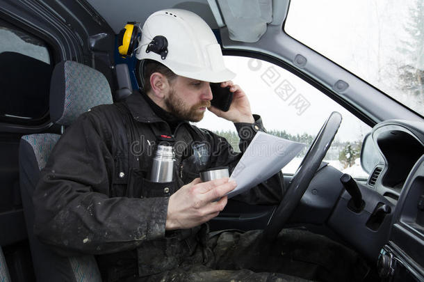 建筑工人在芬兰一边看报纸，一边开车，一边打电话，一边喝咖啡。