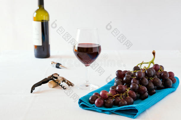 一串红葡萄和一杯带酒瓶的红酒