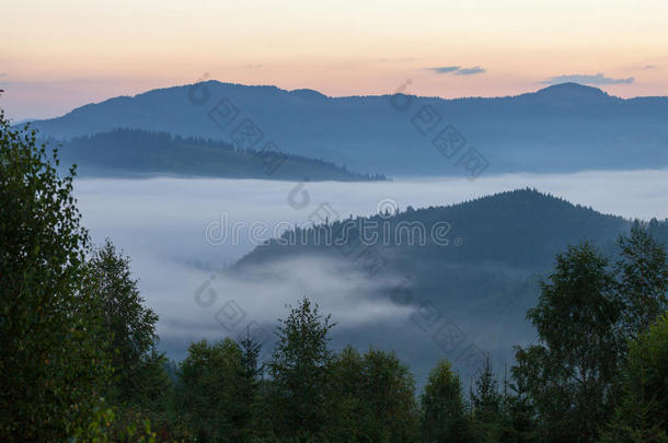 令人惊叹的田园风光，在晨雾中笼罩着连绵起伏的山丘。 山顶农舍的鸟瞰图
