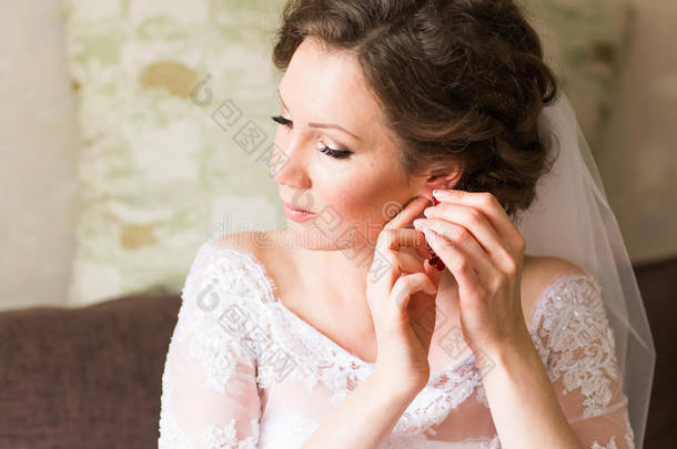 优雅的新娘戴上耳环，为婚礼做准备