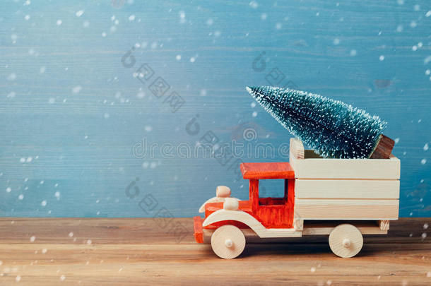 木制桌子上玩具卡车上的圣诞树。 圣诞节节日庆祝概念