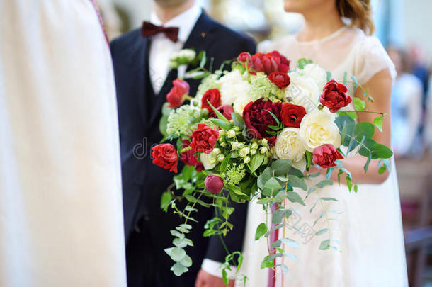 新娘在教堂举行婚礼时拿着一束漂亮的婚礼花束