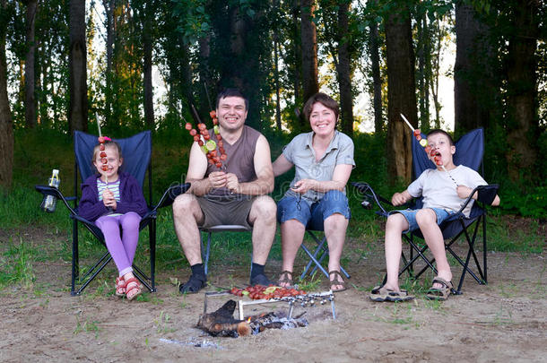 <strong>一家人</strong>在森林里<strong>野餐</strong>，做烧烤，烧肉，背景树
