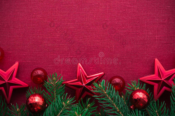 框架与圣诞树和装饰在红色画布背景。 圣诞快乐卡。