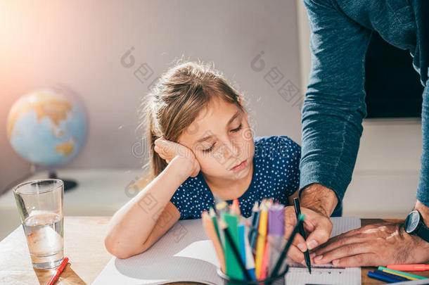 父亲帮助女儿完成家庭作业