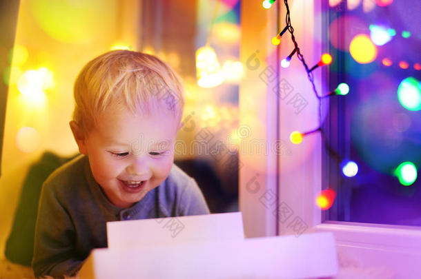 可爱的小男孩看着一个神奇的圣诞节或新年礼物