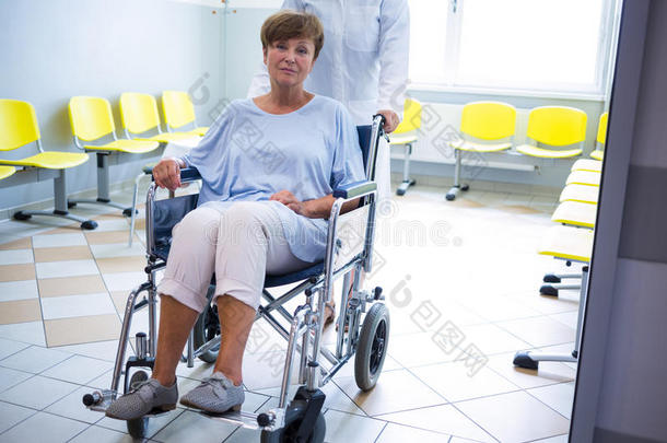 医生把老年病人推到轮椅上