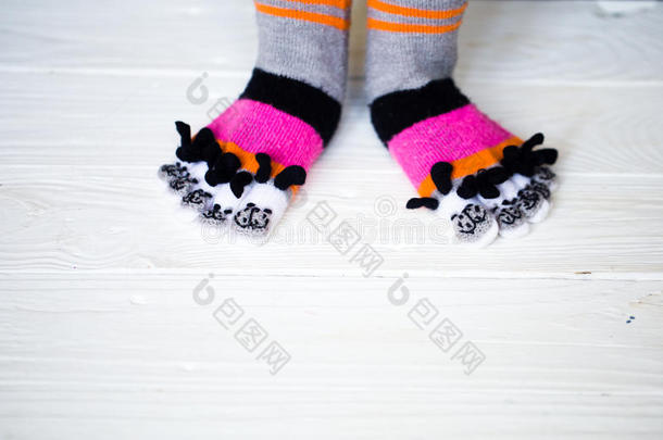 婴儿的脚在温暖的，长的多色袜子与脚趾