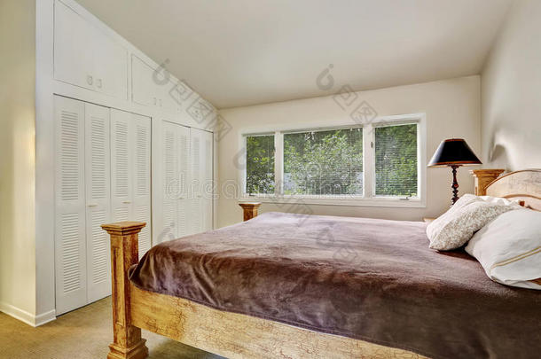 卧室内部有衣柜，木制床和棕色床上用品。