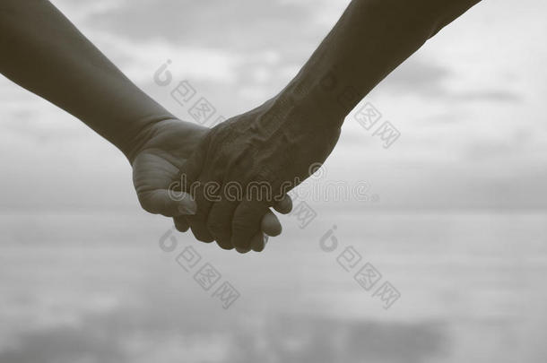 亲密的手，老年夫妇牵着手在海边附近的海滩，<strong>黑白图片</strong>颜色，过滤图像