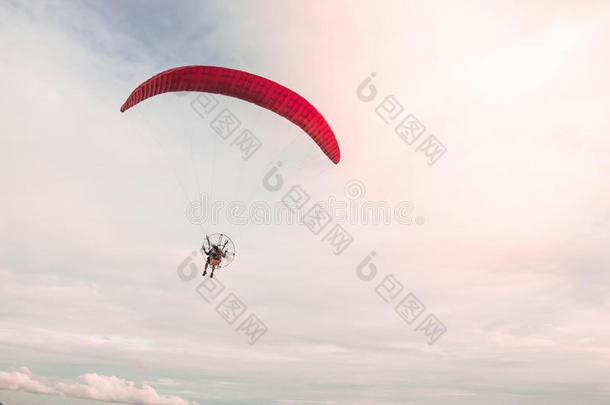 一个男人在夏日的天空背景下，带着副摩托极限运动冒险飞向天空。