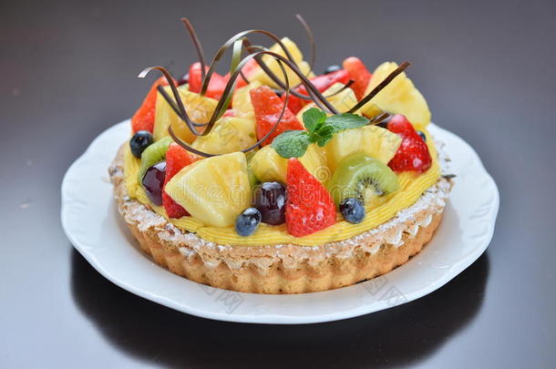 水果蛋糕与草莓菠萝葡萄猕猴桃在白盘上