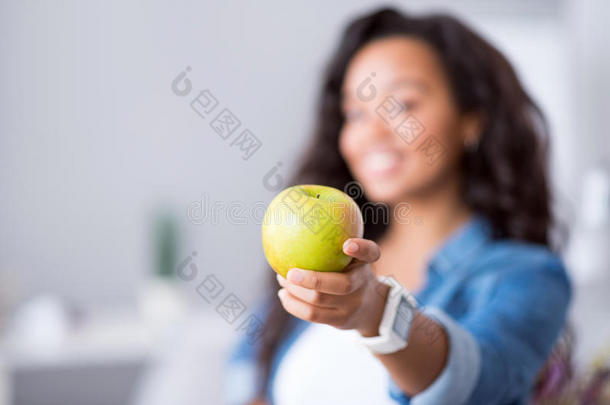 开朗微笑的女人拿着<strong>苹果</strong>。