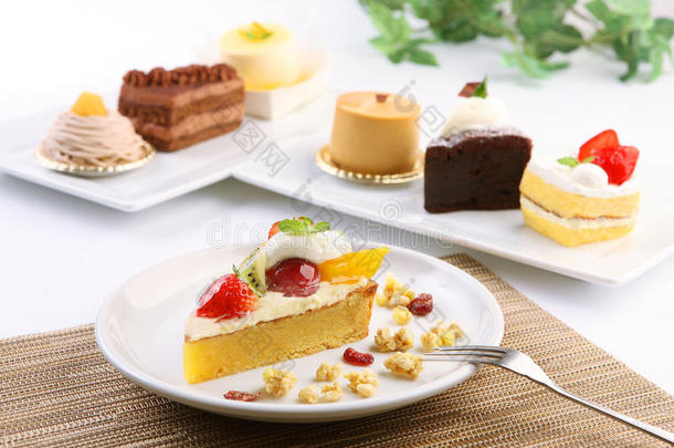 奶油蛋糕甜点，草莓，猕猴桃和芒果在白色