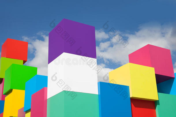 五颜六色的立方体映衬着蓝天白云。 黄色，红色，绿色，粉红色的积木。 潘通的颜色概念