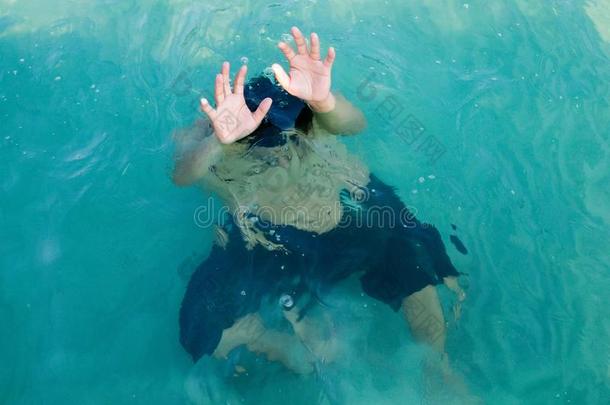 溺水的人在海里请求帮助，举起他的手臂。 安全概念