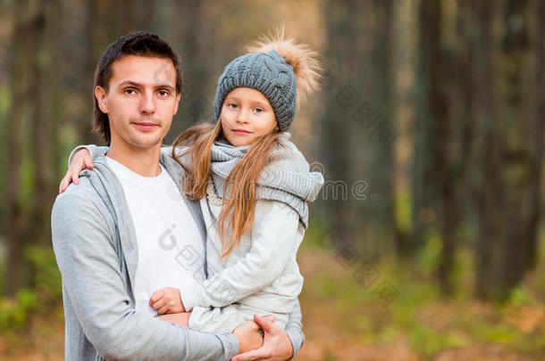 可爱的小女孩和父亲在秋天的公园户外。 幸福的家庭一起享受温暖的秋日