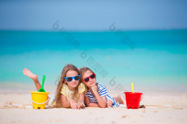 暑假期间可爱的小女孩。 孩子们在白色海滩上