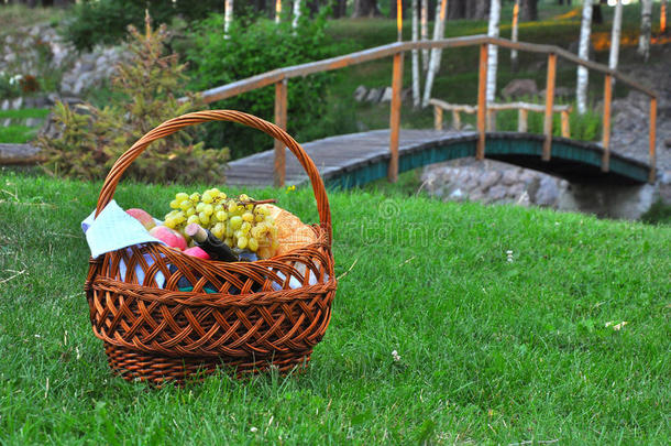野餐篮子的特写，草地上有饮料和食物