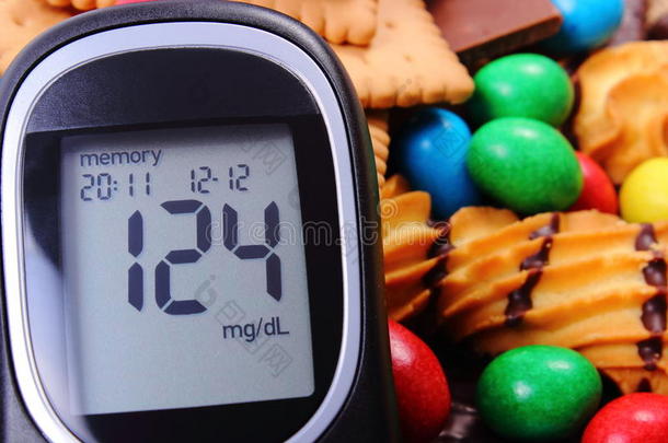 血糖仪，有大量的糖果、糖尿病和不健康的食物