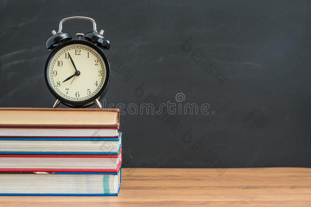 学生桌上黑板前的闹钟和书本