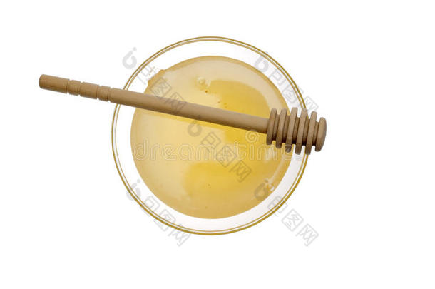 白色背景上的一碗蜂蜜和木制蜂蜜贴纸。