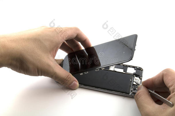 一名男子正在修理他正在准备修理手机他正在拉密封带以便更换电池
