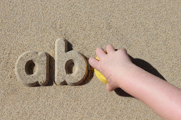 在沙滩上写沙字母的孩子