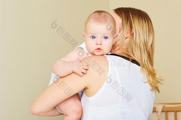 蓝眼睛在妈妈怀里的小男孩。 概念o