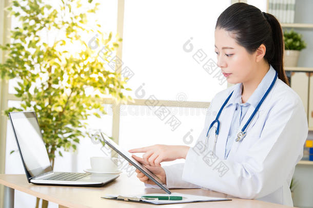 医生用数字平板记录病人`医疗病例