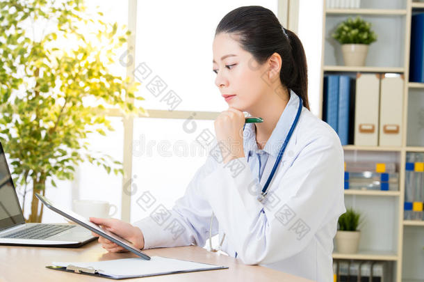医生用数字平板记录病人`医疗病例