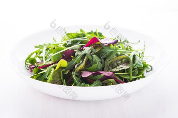 新鲜沙拉与混合蔬菜（阿鲁古拉，梅斯克伦，<strong>砍刀</strong>）在白色木制背景关闭。