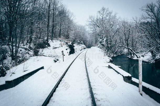 马里兰州乡村卡罗尔县的一条雪覆盖的铁轨和小溪。