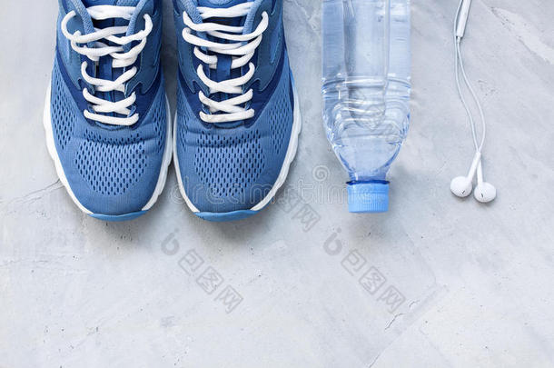 平躺<strong>运动</strong>鞋，瓶子水和<strong>耳机</strong>在灰色混凝土背面。 概念健康的生活方式，<strong>运动</strong>和饮食。