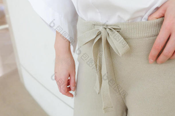 米色拉弦腰休闲<strong>女裤</strong>风格特写细节。 最小的时尚。
