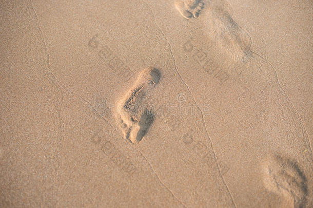 沙子里的脚印。 夏天沙滩上的一排脚印。 暑假
