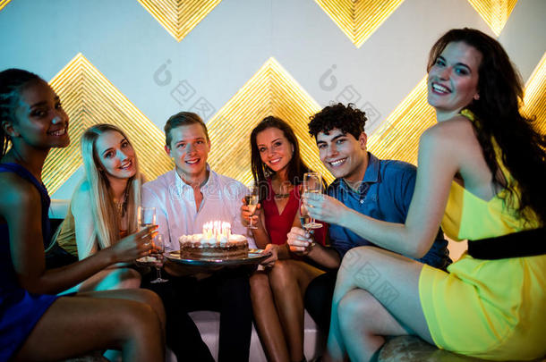 一群微笑的朋友在庆祝生日的时候喝了一杯香槟
